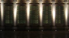 the columns are lined up against the wall with lights shining on them and reflecting in the water