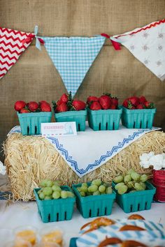 straw bales and baskets filled with fruit on top of a table