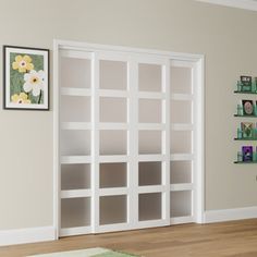 a living room filled with lots of furniture next to a wall mounted book shelf on top of a hard wood floor