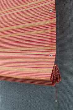 an orange and red striped curtain hanging on the side of a building