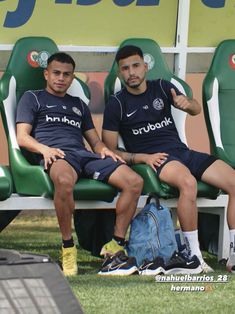 two soccer players are sitting on the bench