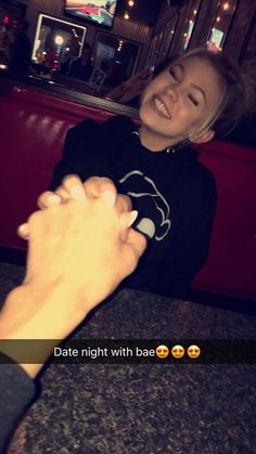 a woman holding the hand of a man in a restaurant