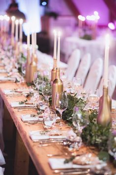 a long table is set with wine glasses and place settings