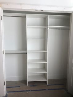 an empty closet with white shelves and blue tape on the floor