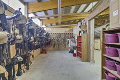 a room filled with lots of different types of saddles and buckets next to each other