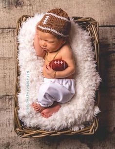 a baby is sleeping in a basket with a football on it