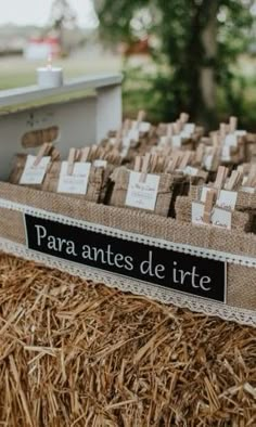 there is a table with place cards on top of hay bales in front of a tree