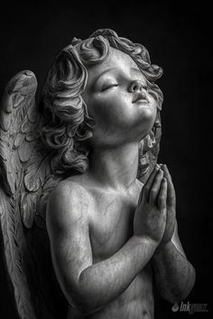 a black and white photo of an angel praying