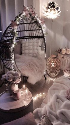 a bedroom with white fur and lights on the walls, a birdcage hanging from the ceiling