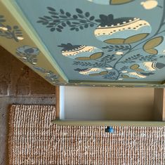 a blue and green painted ceiling in a room with wicker flooring on the bottom