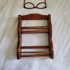 a pair of glasses sitting on top of a bed next to a wooden rocking chair