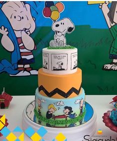 there is a three tiered cake with cartoon characters on it