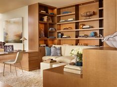 a living room filled with furniture and bookshelves next to a wall full of shelves