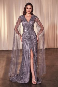 You'll love twirling around in this fully beaded long cape sleeve dress with a fitted slit skirt from Ladivine by Cinderella Divine CD0239. Step into the spotlight with our fully beaded sheath evening gown, featuring a deep V-neckline and intricate beading that highlights your figure. The long, floor-grazing cape sleeves and lower center leg slit add a dramatic flair to this captivating design. Beaded Cape Sleeve Slit Gown by Ladivine CD0239 Illusion V-neck bodice with sheer cape sleeves Enclose Cape Sleeve Dress, Beaded Cape, Flowing Sleeves, Fashion Dresses Formal, Long Cape, Intricate Beading, Cinderella Divine, Sequin Formal Dress, Sheath Gown