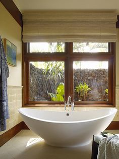 a large white bath tub sitting next to a window