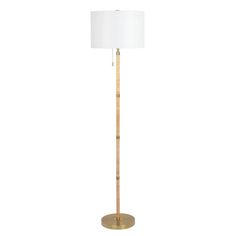 a tall wooden floor lamp with a white shade on the top and gold metal base