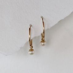 Endless hoops in solid 14k yellow gold are accented with white cultured pearl dangles. The hoops are 15mm in diameter and the cultured pearls are 4mm each. This is not gold filled metal, this is solid 14k gold. A cultured pearl is a genuine pearl, produced by an oyster or mollusk with human assistance. Endless hoops open with a little tension, and you slip the post through your ear and use a little tension to put the post back into the hoop. The pearl dangle can be slipped on and off, creating t Delicate Yellow Gold Hoop Pearl Earrings, Classic Dangle Hoop Earrings With Pearl Charm, Delicate Yellow Gold Hoop Earrings With Pearl Drop, White Teardrop 14k Gold Hoop Earrings, 14k Gold Pearl Charm Huggie Earrings, 14k Gold Hoop Earrings With Pearl Drop For Weddings, Classic Yellow Gold Huggie Earrings With Pearl Charm, 14k Gold Huggie Earrings With Pearl Charm, Everyday 14k Gold Hoop Earrings With Pearl Charm