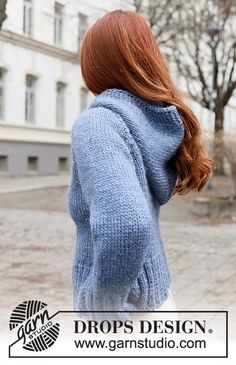 a woman with red hair wearing a blue sweater