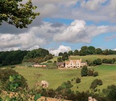 a large house sitting on top of a lush green hillside