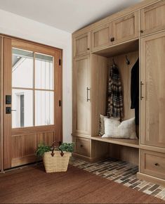 a room with wooden cabinets and a basket on the floor next to an open door