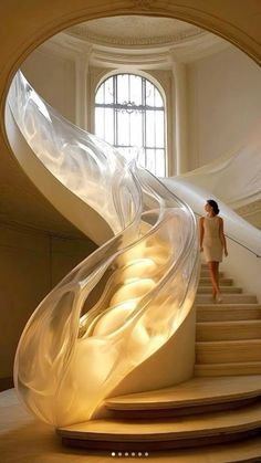 a woman is walking up some stairs in front of a large window with an artistic design on it