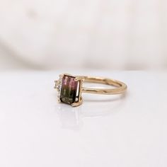 This beautiful ring features a 0.97 carat bicolor (pink & green) tourmaline gemstone with natural earth mined diamonds, all set in solid 14K gold. This ring can be a beautiful October birthstone gift for your loved ones! This ring is made with solid 14K Gold and natural Earth mined SI / G-H diamonds. As listed, this ring is ready to ship. If you're interested in purchasing this setting with a different center stone please message us! Emerald Cut Tourmaline Jewelry With Accent Stones, Tourmaline Rings With Gemstone Accents And Emerald Cut, Emerald Cut Tourmaline Ring With Gemstone Accents, Emerald Cut Tourmaline Ring In Fine Jewelry Style, Emerald Cut Tourmaline Ring Fine Jewelry, Emerald Cut Tourmaline Gemstone Rings, Tourmaline Rings With Gemstone Accents, Designer Silver Jewellery, Jewelry Showcases