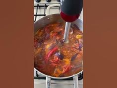 a pot filled with food sitting on top of a stove next to a burner