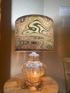 a glass lamp sitting on top of a wooden table