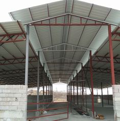 the inside of a building that is being constructed with metal beams and red bars on each side