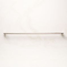 a white wall with a metal bar on the top and one long pole at the bottom