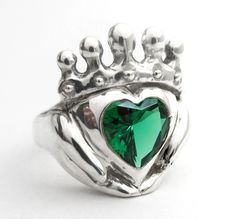 "Claddagh rings are Celtic promise rings, and this emerald ring is modern, unique and can be personalized to create the perfect birthstone jewelry gift for weddings, engagements anniversaries and birthdays. My Claddagh rings are all handmade in my home studio. I set out to create a unique Claddagh design that really shows love and devotion in the hands, heart and crown.  You can even get stones set in the crown! Message for a quote.  The hands are there for friendship,  The heart is there for love.  For loyalty throughout the year,  The crown is raised above  How to can wear your Claddagh Ring: - On the right hand, the heart pointed away, means you are free as the wind. - On the right hand, the heart pointed toward you, then you are spoken for. - On the left hand, the heart pointed towards Heart-shaped Emerald Jewelry With Birthstone, Heart-shaped Emerald Birthstone Jewelry, Sterling Silver Heart Rings For May Birthstone, Sterling Silver Heart Rings With Emerald, Green Heart-shaped Jewelry For Promise, Green Heart-shaped Promise Jewelry, Silver Heart Cut Emerald Ring As Gift, Silver Heart Cut Emerald Ring For Gift, Silver Heart Ring For May Birthstone Gift