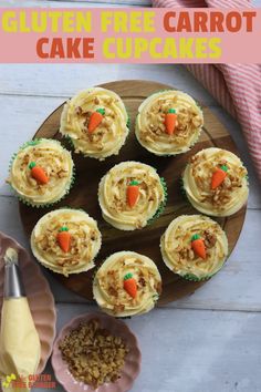 cupcakes with frosting and carrots on a wooden platter next to other dessert items