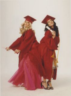 two women in red graduation gowns posing for the camera