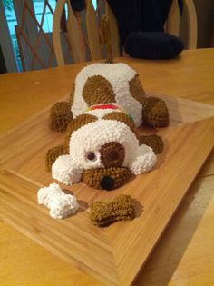 a crocheted dog laying on top of a wooden table