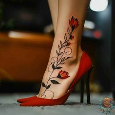 a woman's foot with flowers and leaves tattooed on the side of her leg