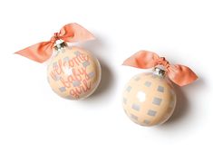 two christmas ornaments with bows on them sitting next to each other