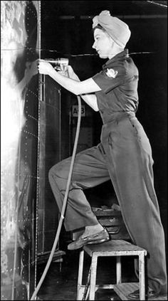 an old black and white photo of a woman in uniform with a hose on her shoulder