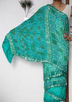 Discover the timeless elegance of our Gaji Silk Saree, a true masterpiece of traditional craftsmanship. Handcrafted from luxurious Gaji silk, this saree offers a lustrous sheen and a smooth, soft texture that drapes beautifully. The intricate patterns and vibrant colours are the result of meticulous hand-dyeing techniques, making each saree a unique piece of art. Perfect for special occasions, weddings, or festive celebrations, our Gaji Silk Saree combines heritage and sophistication.  ➢ Manufac Bollywood Style Green Pre-draped Saree With Motifs, Green Bohemian Silk Saree, Bohemian Green Silk Saree, Fitted Turquoise Traditional Wear, Traditional Fitted Turquoise Saree, Transitional Green Raw Silk Saree, Fitted Traditional Turquoise Saree, Bohemian Green Pre-draped Saree With Dupatta, Transitional Green Art Silk Saree