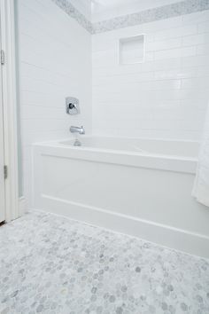 a white bath tub sitting next to a shower