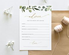 the wedding stationery is laid out on top of a brown envelope with twine and spools of thread