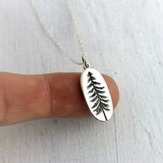 "Sterling Silver Tree Necklace. Pine trees are cultural symbols all around the world. Aside from representing fertility, wisdom and longevity, the pine tree is a symbol of peace. Wherever this special tree grows, it will always be a tree that is featured in legends, and one that gives love and hope. » Top quality solid Sterling Silver charm with soldered jump ring and tiny .925 Sterling hallmark on back. » Approximate charm size: (20mm x 10mm) or (7/8\" x 3/8\") » The pine tree has been etched a Green Nature-inspired Everyday Jewelry, Everyday Green Nature-inspired Jewelry, Green Tree Of Life Jewelry Gift, Nature-inspired Leaf Jewelry Gift, Nature-inspired Green Jewelry With Birth Flower, Nature-inspired Etched Jewelry For Gifts, Nature-inspired Etched Jewelry Gift, Symbolic Green Engraved Necklaces, Green Engraved Necklace For Gift