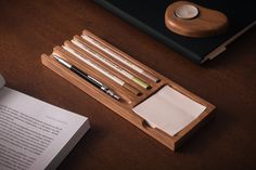 a wooden desk with some pens and pencils on it