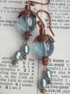 some kind of wire wrapped earrings on top of an open page with the caption