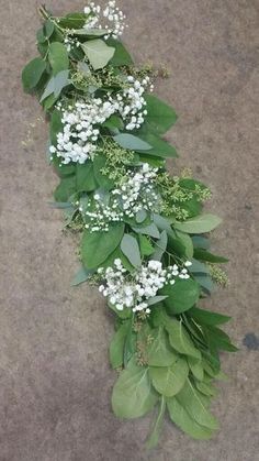 some white flowers and green leaves on the ground