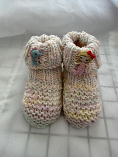 These hand-knitted baby booties are a must-have for any parent looking for a unique and personalized touch to their baby's wardrobe. The hand-knitted design adds a special touch to the booties, making them stand out from mass-produced items. The hand-knitted process also ensures that each pair of booties is unique, making them a one-of-a-kind addition to your baby's wardrobe. The hand-knitted baby booties are not only stylish but also comfortable and practical. The soft and cozy material ensures that your baby's feet stay warm and comfortable, while the non-slip design provides added safety and stability for your little one. The booties are also easy to put on and take off, making them a convenient choice for parents on the go. These hand-knitted baby booties are perfect for any occasion, Cozy Knitted Booties With Round Toe, Cute Yarn Booties As A Gift, Cute Yarn Booties As Gift, White Hand Knitted Booties As Gift, Cute Handmade Pink Booties, Handmade Casual Booties As Gift, Handmade Round Toe Booties As Gift, Cute Pink Booties For Gift, Handmade Round Toe Booties Gift