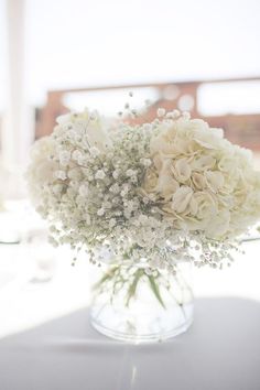 a vase filled with white flowers on top of a table