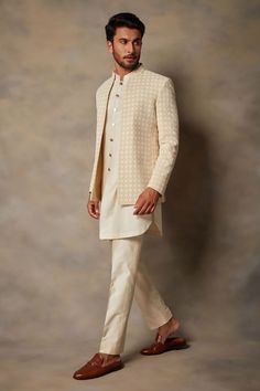 a man in a white suit and tan shoes