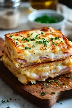 two sandwiches stacked on top of each other with cheese and meat in the middle, sitting on a wooden cutting board