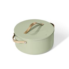 a round green pot with gold handles