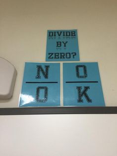 two stickers on the wall that say divide by zero? and no ok, next to a computer mouse